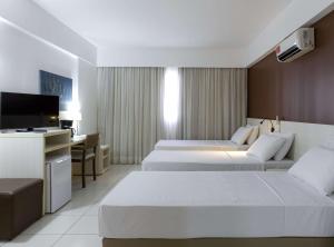 Cama ou camas em um quarto em Best Western Suites Le Jardin Caldas Novas