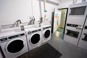 a laundry room with two washing machines and a sink at Attic Backpackers in Auckland