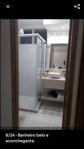 y baño con ducha acristalada y lavamanos. en Alugo apartamento perto de Porto de Galinhas en Ipojuca