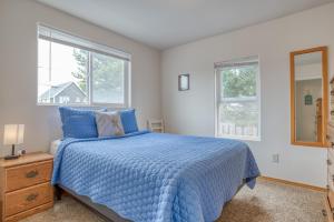Un dormitorio con una cama azul y dos ventanas. en Beach Street Getaway- Seaside - Meredith Lodging, en Seaside