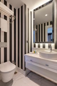 a bathroom with a sink and a toilet and a mirror at Motif Hotel Çeşme in Çeşme