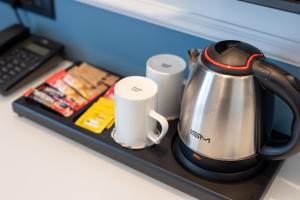 a tea kettle and two cups on a tray at Motif Hotel Çeşme in Çeşme