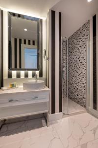 a bathroom with a sink and a mirror and a shower at Motif Hotel Çeşme in Çeşme