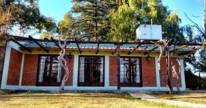 a red and white brick building with trees at Casa Quinta Rodeada de Bodegas Piscina BBQ Mendoza in Maipú