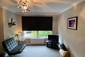 TV at/o entertainment center sa Peter Pan Apartment in the heart of Inverness