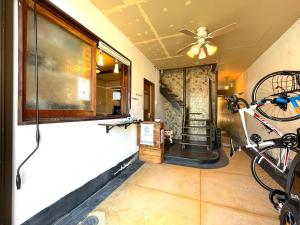 Zimmer mit einem Deckenventilator und einem Fahrrad an der Wand in der Unterkunft 島宿Nest in Onomichi