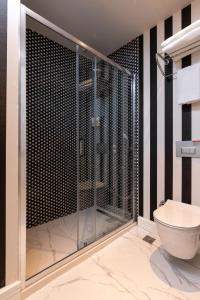a bathroom with a glass shower and a toilet at Motif Hotel Çeşme in Çeşme