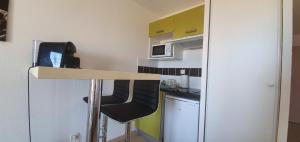 una pequeña cocina con barra y silla en Studio Vue Mer Circuit Paul Ricard - Domaine Securisé, en Signes