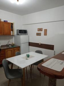 eine Küche mit einem Tisch und Stühlen sowie einem weißen Tisch in der Unterkunft Departamento Pleno Centro de Mendoza, Argentina in Mendoza