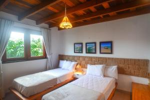 two beds in a room with two windows at Reserva Barra Grande in Barra Grande