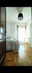 a bedroom with a bed and a wooden floor at NO FIESTAS, 5 DORMITORIOS Solo familias, parejas o trabajo PARKING Público Gratis a 300m in Toledo