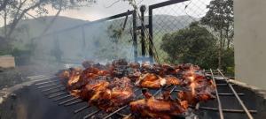 a bunch of chickens cooking on a grill at The Butterfly cottage Vagamon in Vagamon