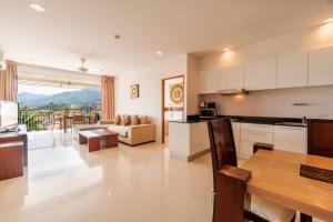 uma cozinha e sala de estar com um sofá e uma mesa em The Park Surin Serviced Apartments em Praia de Surin