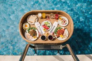 a table of food on a chair near a swimming pool at Ubud Hotel & Cottages in Malang