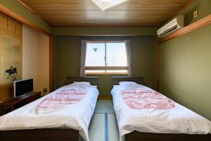 Voodi või voodid majutusasutuse Tabist HotelNakajima Fuji toas
