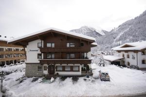 a snow covered building with a car parked in front of it at Roasnerhof in Finkenberg