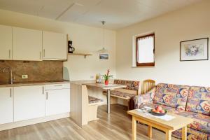 a kitchen and a living room with a couch and a table at Ferienwohnungen Haus Christine in Rifiano +18 photos