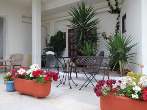 a patio with flowers and a table and chairs at Hotel Il Platano in Ottana