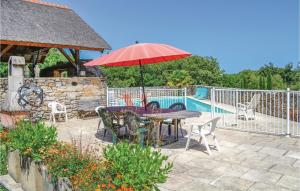 a patio with a table with an umbrella and chairs at Awesome Home In Padirac With Kitchenette in Padirac