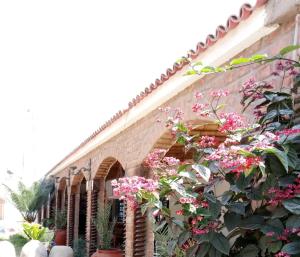 Un edificio con flores en el costado. en Hostal Loma Blanca, en Ica