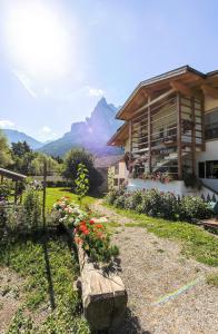 uma casa com flores à sua frente com uma montanha em Peterlungerhof em Siusi