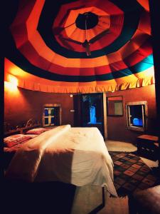 ジョードプルにあるChhotaram Prajapat Home Stayのカラフルな天井のベッドルーム1室(大型ベッド1台付)