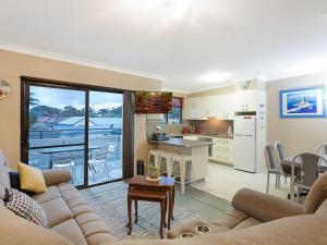 a living room with a couch and a kitchen at Apollo Unit 7 1st Floor in Narooma