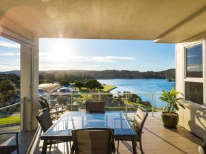 a table on a balcony with a view of the water at Wharf Apartment Unit 11 in Narooma