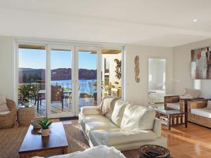 un salon avec un canapé blanc et une table dans l'établissement Wharf Apartment Unit 11, à Narooma