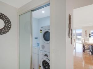 - une buanderie avec un lave-linge et un sèche-linge dans l'établissement Wharf Apartment Unit 11, à Narooma