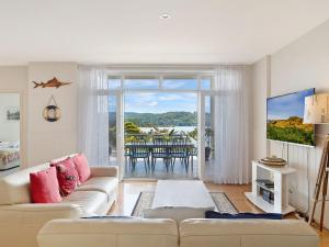 sala de estar con sofá y vistas al océano en Wharf Apartment Unit 5 en Narooma