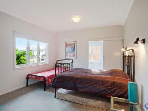 a bedroom with a bed and a window at 84 Ocean Parade in Dalmeny