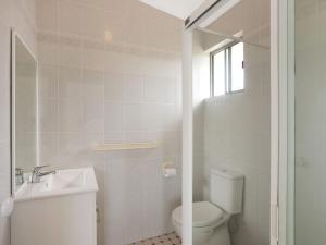 La salle de bains blanche est pourvue de toilettes et d'un lavabo. dans l'établissement Unit 2 43 Noble Parade Dalmeny, à Dalmeny