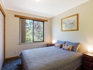 a bedroom with a large bed and a window at Unit 1, 2b Harrington Road in Narooma