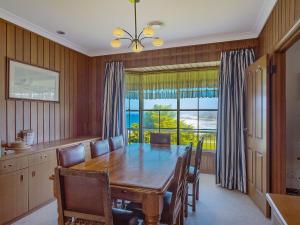 a dining room with a table and a large window at 120 Ocean Parade Dalmeny in Dalmeny
