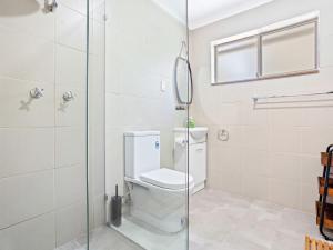 a bathroom with a toilet and a glass shower at Braeside Cabin Four Ziera in Central Tilba