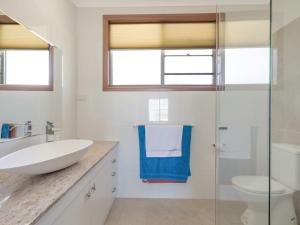 Un baño con lavabo y ducha de cristal. en 120 Ocean Parade Dalmeny, en Dalmeny 23 fotos más