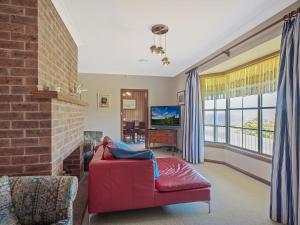 
a living room with a couch, chair and a window at 120 Ocean Parade Dalmeny in Dalmeny
