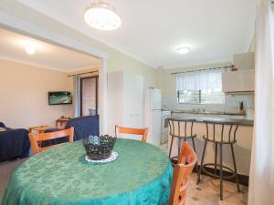 a room with a table and chairs and a kitchen at Apollo Unit 23 First Floor in Narooma