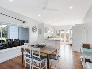 een keuken en eetkamer met een tafel en stoelen bij Kesla Beach House in Narooma