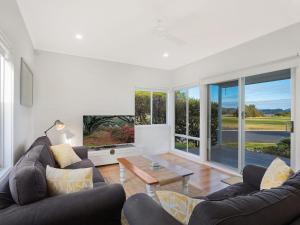 a living room with two couches and a table at Kesla Beach House in Narooma