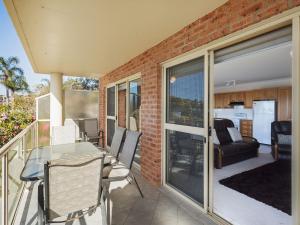 ナルーマにあるGrand Pacific 2 Unit 2 - Ground Floorのバルコニーにテーブルと椅子が置かれたパティオ