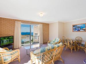 
a living room filled with furniture and a tv at Countess Court Unit - Great Ocean Views in Narooma
