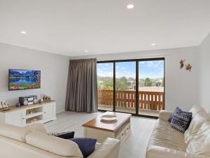 
a living room filled with furniture and a window at Forsters Bay Haven in Narooma
