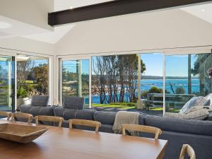 
a living room filled with furniture and a large window at Dollini Ocean (Unit 1) in Dalmeny
