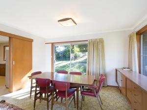 d'une salle à manger avec une table, des chaises et une fenêtre. dans l'établissement 2 Water Crescent Retro Haven, à Kianga