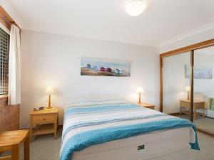 ナルーマにあるGrand Pacific 1 Unit 3 - First Floorの白いベッドルーム(ベッド1台、ランプ2つ付)