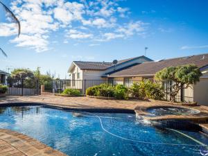 a swimming pool in front of a house at 106 Ocean Parade Dalmeny in Dalmeny