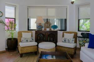 sala de estar con 2 sillas y sofá en Royal Palms 9 condo, en Playa del Carmen