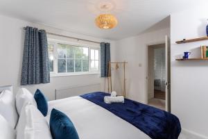 sypialnia z dużym łóżkiem z niebieskimi poduszkami w obiekcie Maunsell House - Lovely central home near Designer Outlets & town with parking w mieście Ashford